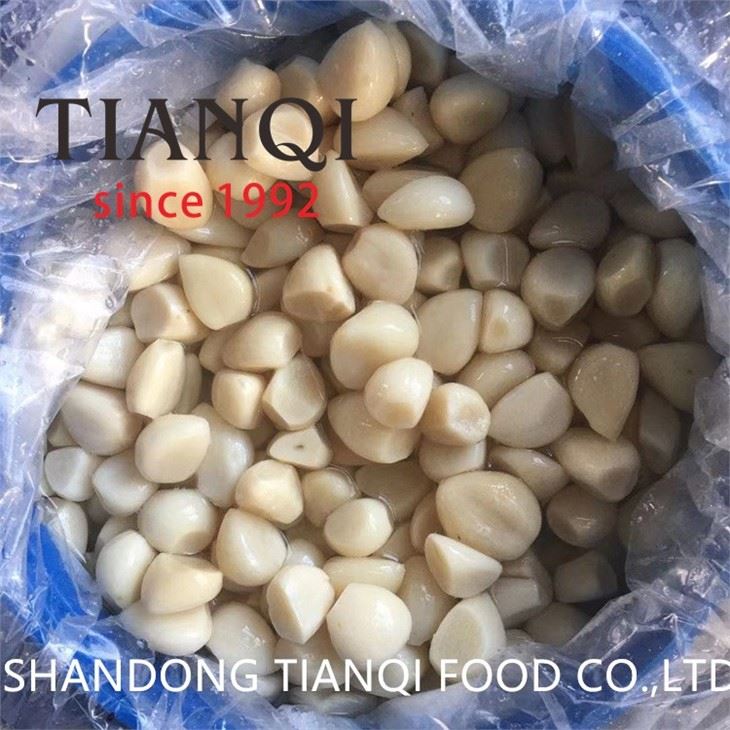White garlic cloves in brine in drums